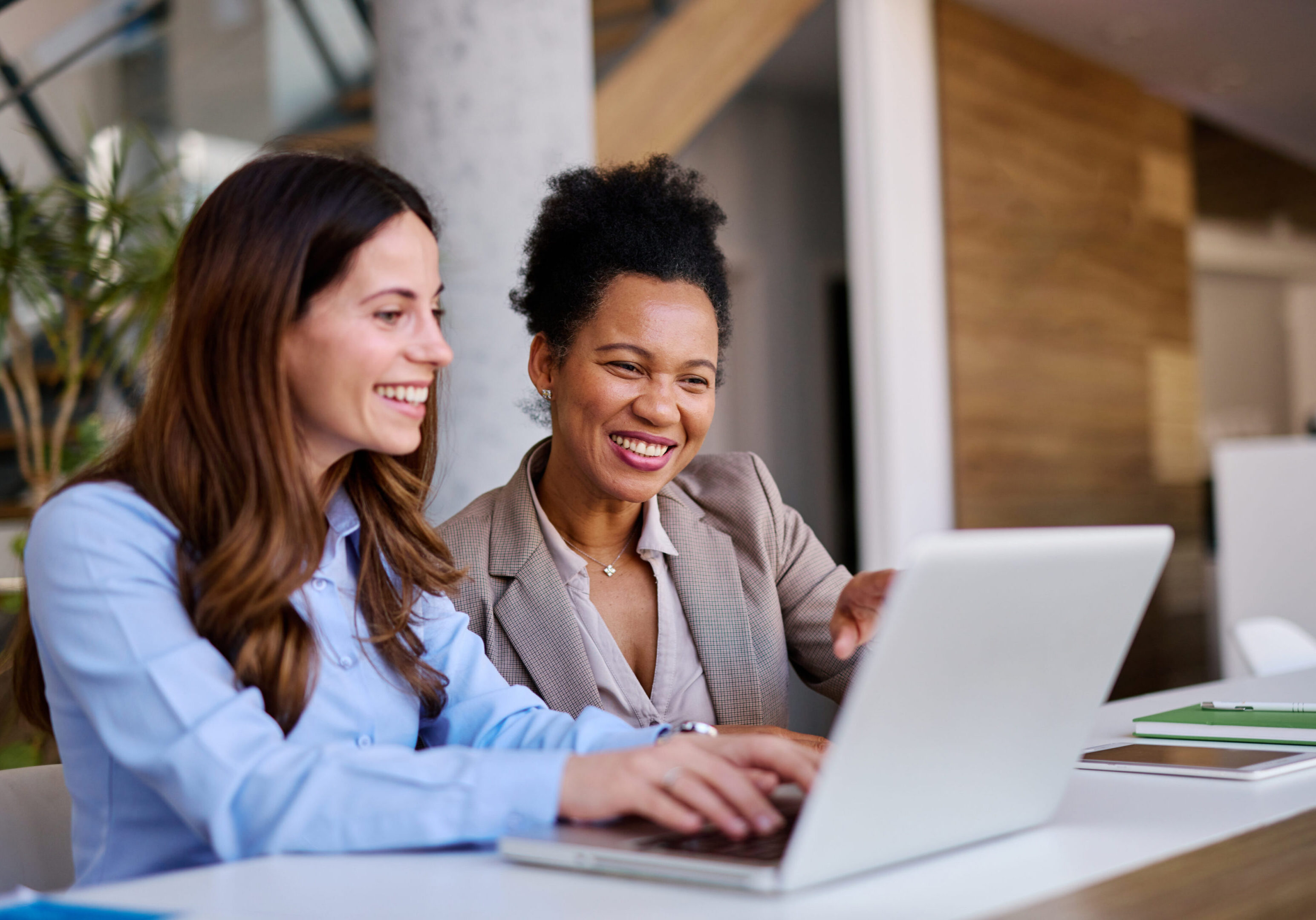 Two women smiling at a laptop